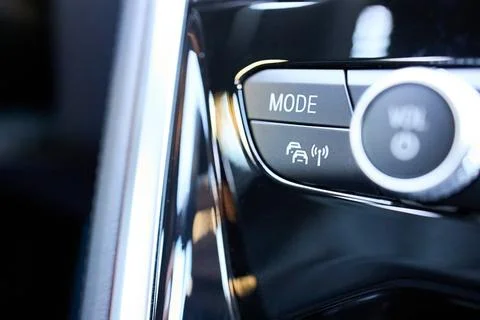 Glossy black panel with chrome-ringed control knob and physical buttons for.. Stock-Fotos