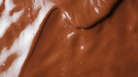 Glossy liquid chocolate wave creeping over smooth background slow motion macro Stock Footage 345661201