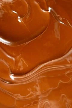 Glossy melted chocolate waves abstract background vertical macro shot Stock Photos