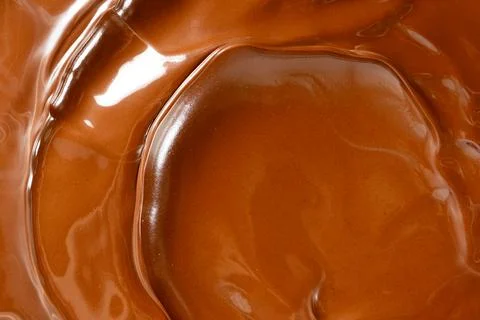 Glossy melted chocolate waves abstract background vertical macro shot Stock Photos