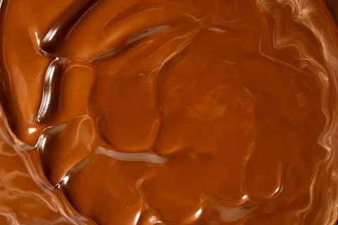 Glossy melted chocolate waves abstract background vertical macro shot Stock Photos