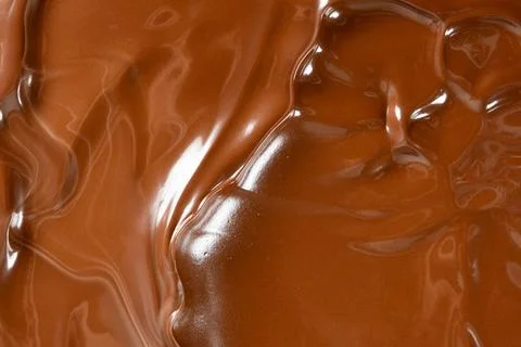 Glossy melted chocolate waves abstract background vertical macro shot Stock Photos