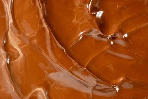 Glossy melted chocolate waves abstract background vertical macro shot Stock Photos