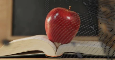 Glossy red apple on book getting wrapped by drifting binary grid before Stock Footage 311125732