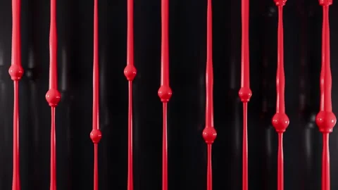 Glossy red paint dripping down vertical streams on black background Vídeo Stock 348061259
