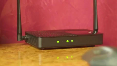 On the glossy surface of the desktop there is a router distributing the Internet Stock Footage 287941991