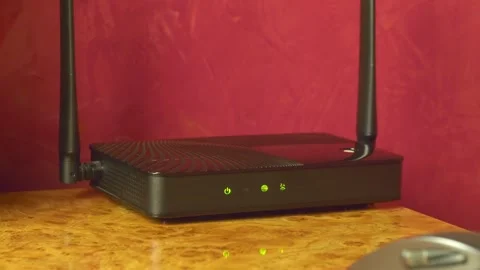 On the glossy surface of the desktop there is a router distributing the Internet 動画素材 287952676
