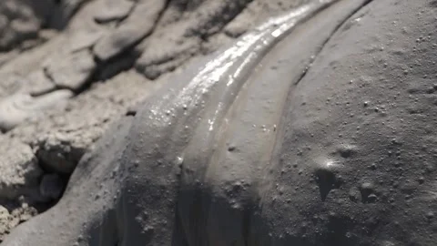 Glossy texture and rippled pattern of flowing liquid wet mud Stock Footage 339270075