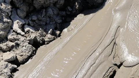 Glossy texture and rippled pattern of flowing liquid wet mud Stock Photos