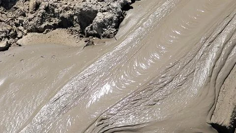 Glossy texture and rippled pattern of flowing liquid wet mud Stock Photos