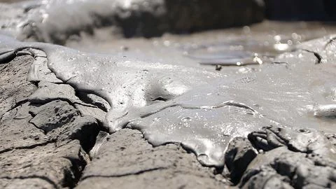 Glossy texture and rippled pattern of flowing liquid wet mud Stock Photos