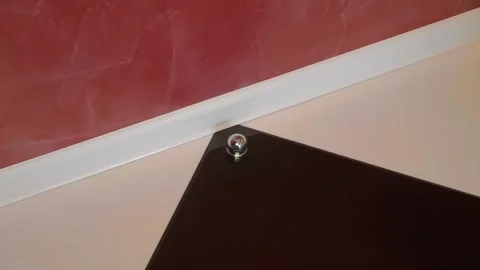 On the glossy tile floor, there is a chrome door stopper protecting the wall Stock Footage 297815496