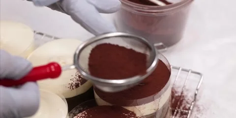 Gloved Baker Dusting Cocoa Powder on Individual Tiramisu Cups Видео 343589160