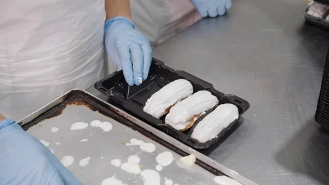 Gloved Baker Packing Iced Eclairs for Retail Sale. Stock Footage 321823046