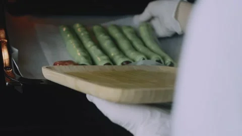 Gloved baker sliding the pastry tray into the oven Stock Footage 342129081
