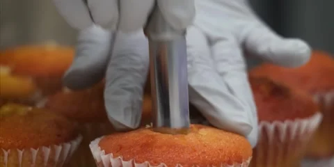 Gloved Baker Using Metal Plunger Corer Tool to Core Freshly Baked Cupcakes for F 스톡 동영상 343588664