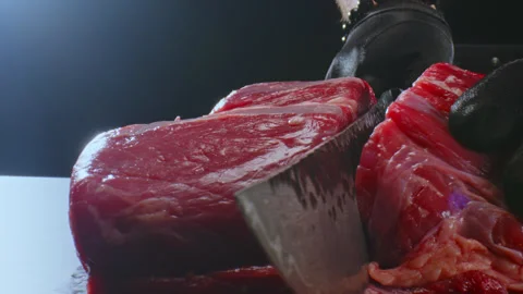 A gloved chef cuts a piece of meat on a cutting board with a kitchen knife. Stock Footage 271253147