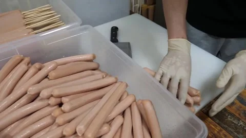 Gloved Chef Preparing Sausages and Corndogs on White Cutting Board Video stock 343587551