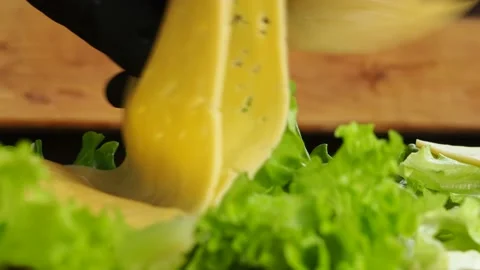 A gloved chef puts lettuce leaves on a large sandwich. 4K Stock Footage 134903165