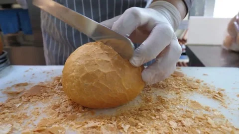 Gloved Chef Slicing Crispy Golden Bread Roll on Cutting Board Video stock 343587327