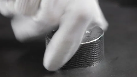Gloved hand adjusting a knurled round metal knob on dark background, Close-up of Stock Footage 306404511