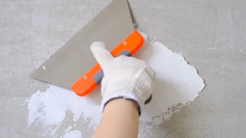 Gloved hand applies plaster to the wall with spatula close-up, repair concept. Stock Footage 229595525