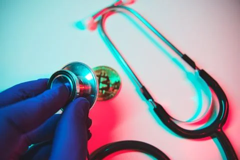Gloved hand checking bitcoin value with stethoscope Stock Photos