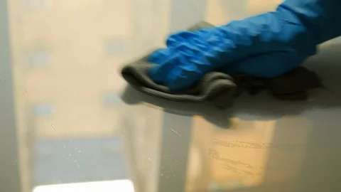 Gloved hand cleaning a glass surface Stock Footage 106659574