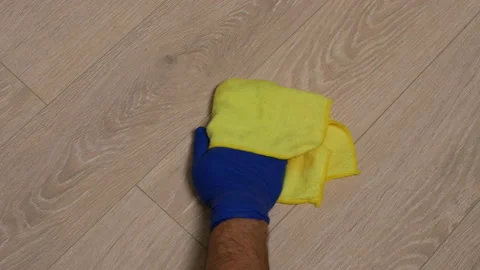 Gloved hand cleaning a spot on floor Stock Footage 147013327