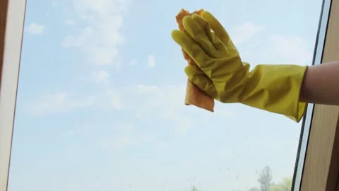 Gloved hand with cleaning spray and cloth, ensuring streak-free windows. Thoroug Stock Footage 301307538