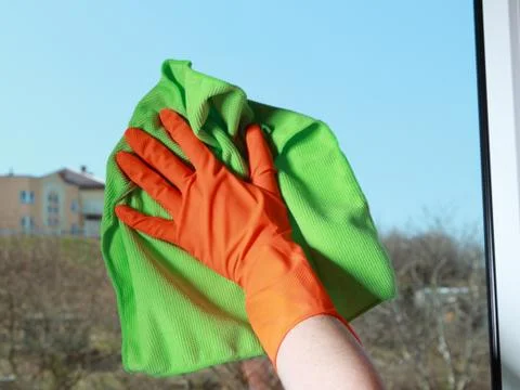 Gloved hand cleaning window with rag Stock Photos