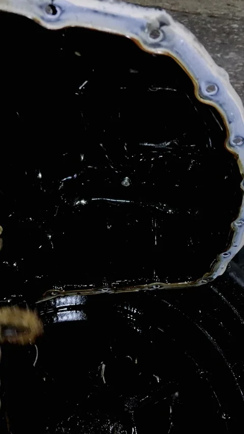 A gloved hand cleans a dirty black car engine oil pan Stock Footage 336559623