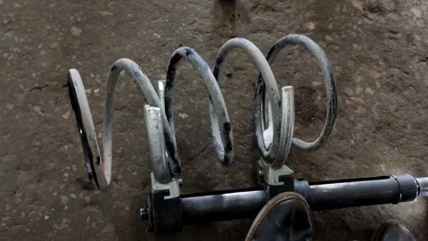 A gloved hand compresses a car coil spring with clamps Stock Footage 335834278