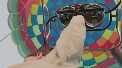Gloved Hand Controlling Flame Under Vibrant Hot Air Balloon Canopy Stock Footage 317192714