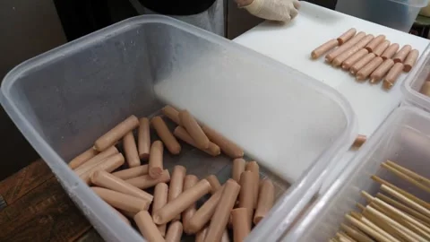 Gloved Hand Counting and Sorting Hot Dogs in Plastic Container Video stock 343587612