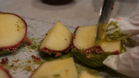 Gloved Hand Cutting Fresh Apple Slices on a Cutting Board 스톡 동영상 345292839