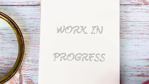 A gloved hand diligently inscribes WORK IN PROGRESS onto a white notebook Stock Footage 331564496
