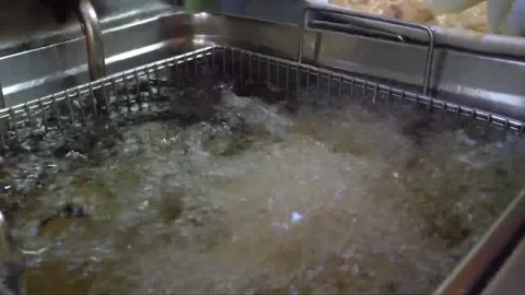 Gloved Hand Dropping Battered Food Item Into Commercial Deep Fryer Video stock 343026969