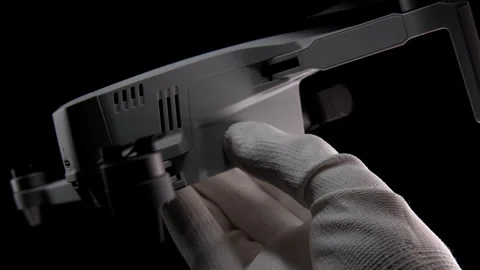 Gloved Hand Holding a Compact Drone Against a Black Background at Night Stock Footage 276297639