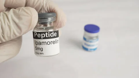 Gloved hand holding an ipamorelin peptide vial Stock Footage 345091507