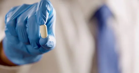 Gloved hand holding pill Stock Footage 320094503