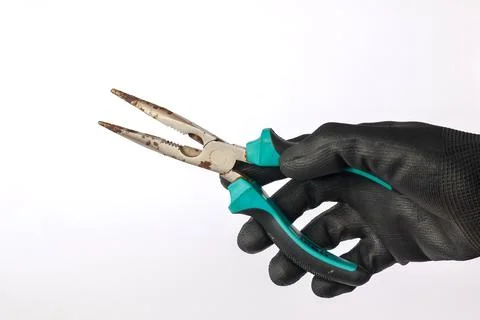 Gloved hand holding a rusty long nose pliers isolated background. Stock Photos