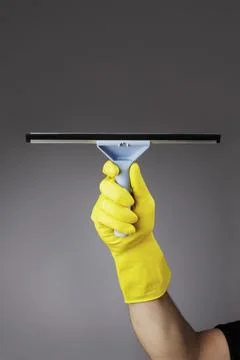 A gloved hand holding a squeegee Foto stock