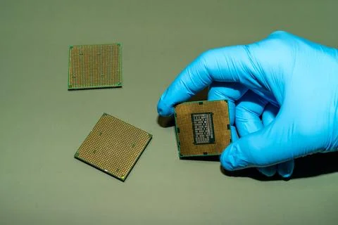 A gloved hand holds a CPU, showcasing computer technology and microchips on.. Stock Photos