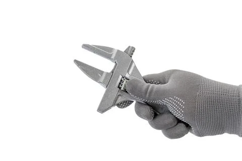 A gloved hand holds small width wrench against white background Stock Photos