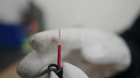 Gloved hand inspecting stripped copper wire for electrical usage Video stock 319503638