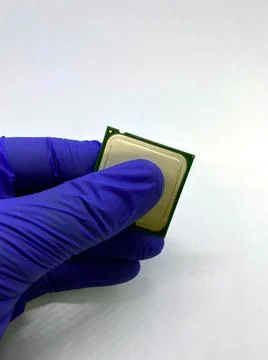 Gloved hand keeping a microprocessor closeup view isolated on white Stockfoto's
