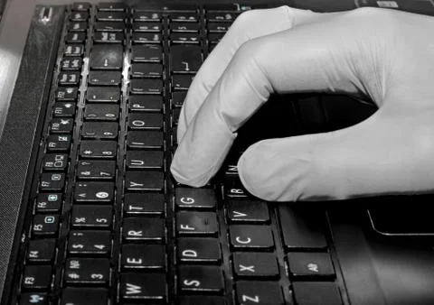 Gloved hand on the keyboard Stock Photos