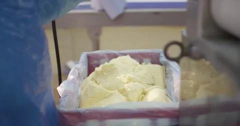 Gloved hand lifting a butter block from a crate, Food Factory Stock Footage 340027783