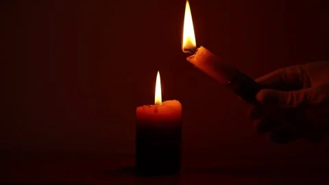 Gloved hand lights a candle from another candle flame in the dark, candle light Stock Footage 312376056
